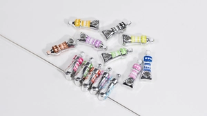 Detailed view of colorful paint tube alloy pendants with love engraving for DIY jewelry
