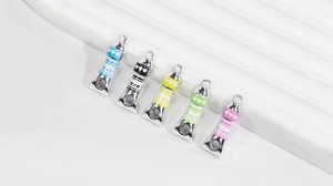 Macro detail of five silver-polished paint tube pendants with colorful love engravings
