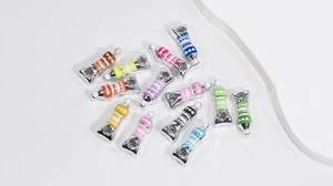 Macro shot of colorful enamel paint tube charms with love text for DIY jewelry making