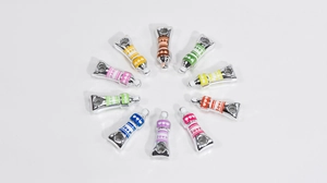 Macro shot of 10 colorful enamel love paint tube pendants for DIY jewelry and keychain