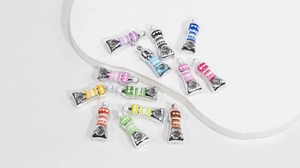 Macro detail of acrylic silver paint tube charms with colorful heart stripes for DIY jewelry