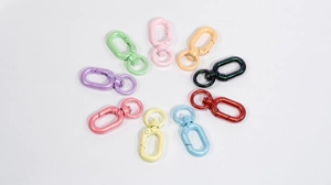 Nine colorful glitter oval spring snap hooks arranged in a circle for DIY crafts