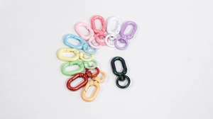Macro detail of colorful glitter alloy lobster clasps with rotating swivel ring hooks