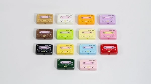 Primer plano de dijes de casete retro para joyería DIY con el texto HITS 90'S