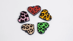 Dettaglio di cinque ciondoli a cuore leopardati con texture floccata per gioielli fai-da-te