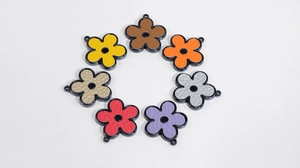 Dettaglio di sette pendenti floreali in acrilico in vari colori con trama in pelle