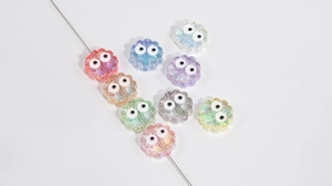 Macro detail of acrylic flower beads with colorful AB coating and big eye patterns