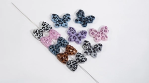 Detail showing colorful leopard print acrylic butterfly beads with threading holes