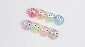 Macro shot of colorful acrylic flower beads with googly eyes for DIY jewelry making