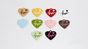 Macro detail of colorful heart charms with love engraving for DIY jewelry making