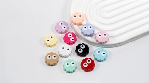 Macro shot of colorful petal shaped acrylic beads with cartoon eyes for DIY jewelry making