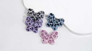 Detailed view of colorful acrylic leopard print butterfly charms for DIY jewelry making
