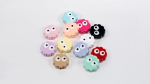 Detail of colorful flower-shaped acrylic beads with eyes for DIY jewelry making