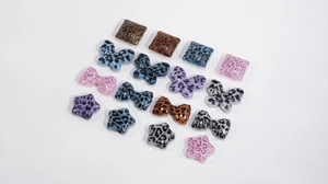 Close-up of leopard print acrylic charms in butterfly, star, and bow shapes for DIY jewelry