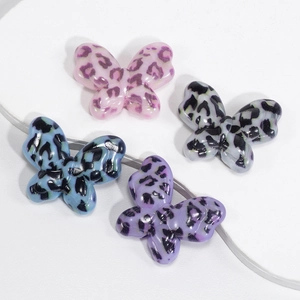 Leopard print acrylic butterfly pendants in four colors on minimalist white stands
