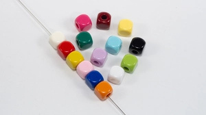 Macro shot of colorful acrylic square beads with pre-drilled holes for DIY jewelry