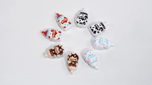 Vue macro des perles biberon en acrylique avec motif vache pour bijoux DIY