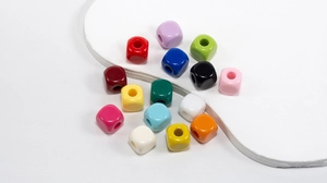 Close-up of colorful square acrylic beads with center holes for DIY craft jewelry