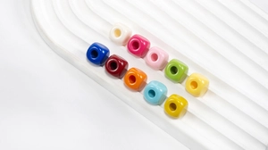 Close-up of colorful square acrylic beads with center holes for DIY jewelry making
