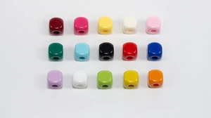 Macro view of fifteen colorful acrylic square beads with central holes for DIY jewelry making