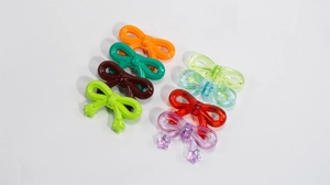 Close-up of colorful acrylic bow pendants in solid and translucent styles with star charms