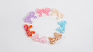 Close-up of colorful acrylic bow beads with holographic star ends in a circular layout