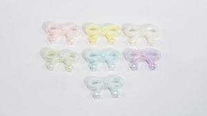 Detailed view of iridescent acrylic bow charms in seven colors for DIY jewelry crafting