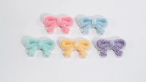 Close-up of colorful plush ribbon bow charms for DIY phone chains and accessories