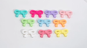 Flat lay of colorful acrylic bow beads for DIY phone chains and jewelry accessories