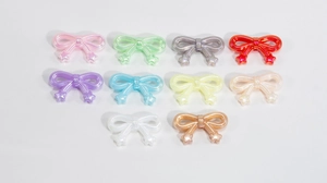 Detail view of colorful acrylic bow-knot beads with stars in ten different glossy colors