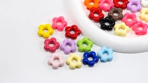 Macro shot of colorful acrylic five-petal flower beads with center holes for DIY crafts