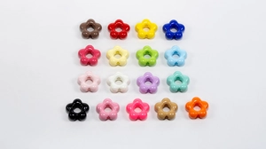 Flat lay of colorful flower acrylic beads with holes for DIY jewelry making and crafts