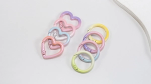 Macro detail of gradient heart and round metal spring ring clasps with glitter finish