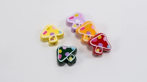 Close-up of colorful mushroom charms with dotted caps for DIY handmade jewelry crafts