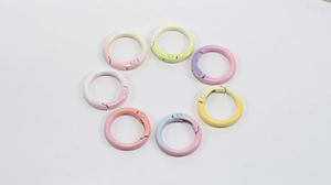 Macro view of seven gradient colorful zinc alloy round spring buckles on white background