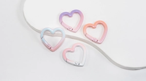 Macro shot of heart-shaped gradient spring clasps in macaron colors on a white board
