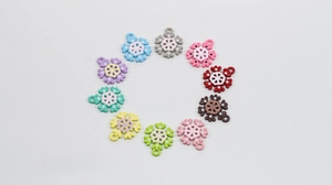 Makro-Detail von zehn bunten Schneeflocken-Anhängern für DIY-Schmuck mit Aufhängern