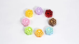Detailed view of colorful cat paw resin beads for DIY jewelry making in various colors