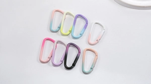 Close-up of D-shaped alloy snap hooks with vibrant gradient spray-painted finishes