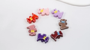 Détail de breloques en résine en forme de chien avec nœuds pour bijoux DIY colorés