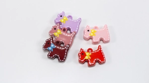 Détail de pendentifs chiens Scottie colorés avec coutures blanches et petits nœuds