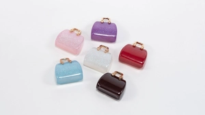 Macro shot of colorful acrylic handbag charms with glitter finish and gold metal handles