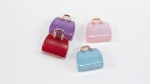 Close-up of glittery resin handbag charms in purple red pink and blue for DIY jewelry