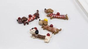 Close-up of colorful acrylic dachshund charms with red apple accents for DIY crafts