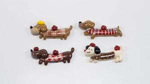 Detail view of four cute acrylic cartoon dachshund dogs with stylish patterned outfits