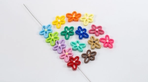 Macro shot of colorful hollow flower beads with white center dot for DIY necklace making