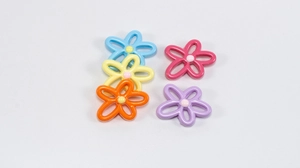 Macro shot of colorful hollow flower pendants in blue, yellow, and pink for DIY jewelry