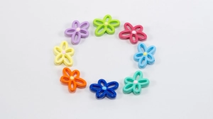 Macro shot of colorful hollow flower beads for DIY jewelry making in eight vibrant shades