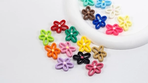 Close-up of colorful hollow flower beads for DIY jewelry making on white tray