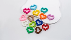 Macro shot of colorful pixel art heart beads with side hole design for DIY jewelry making